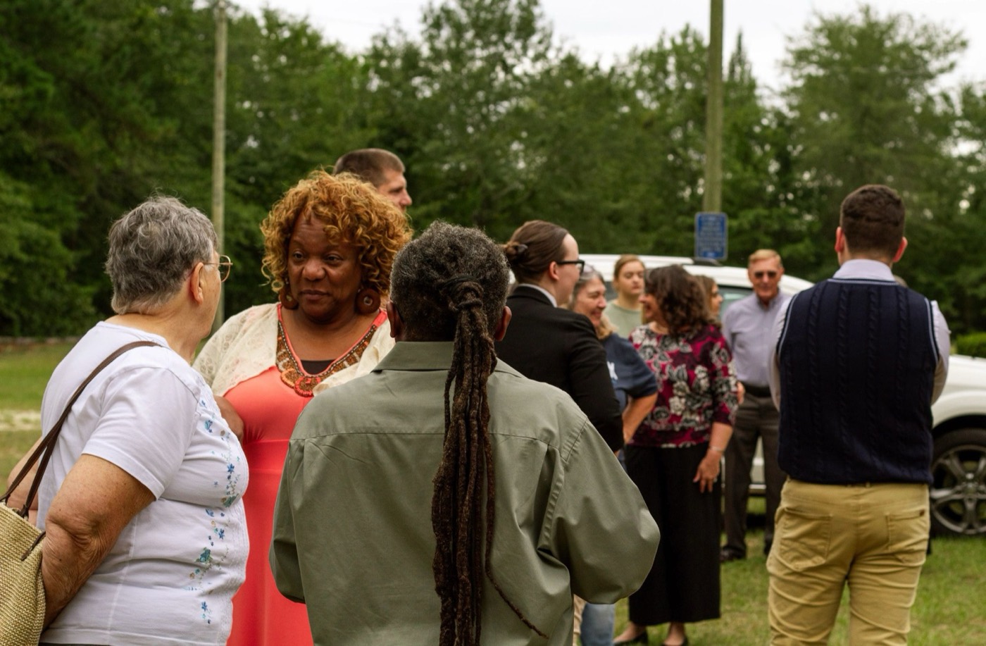 Members of Hillcrest talking in a circle on the lawn outside the church